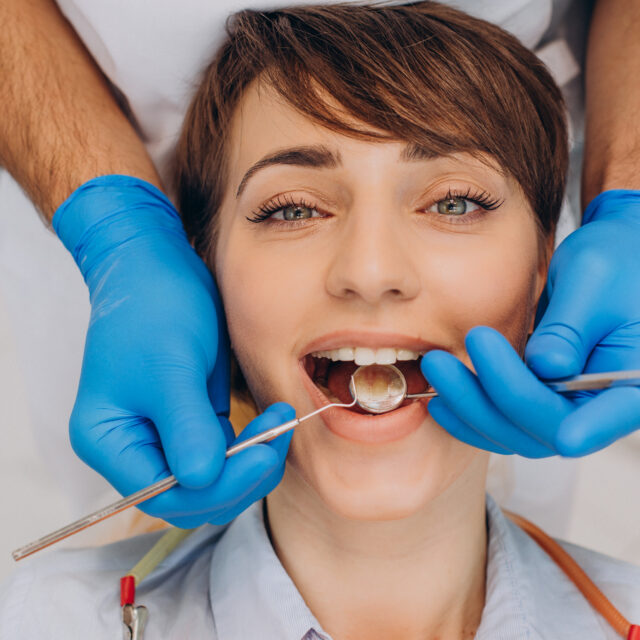 Female patient sitting in a dentist chair and making professinal hygien